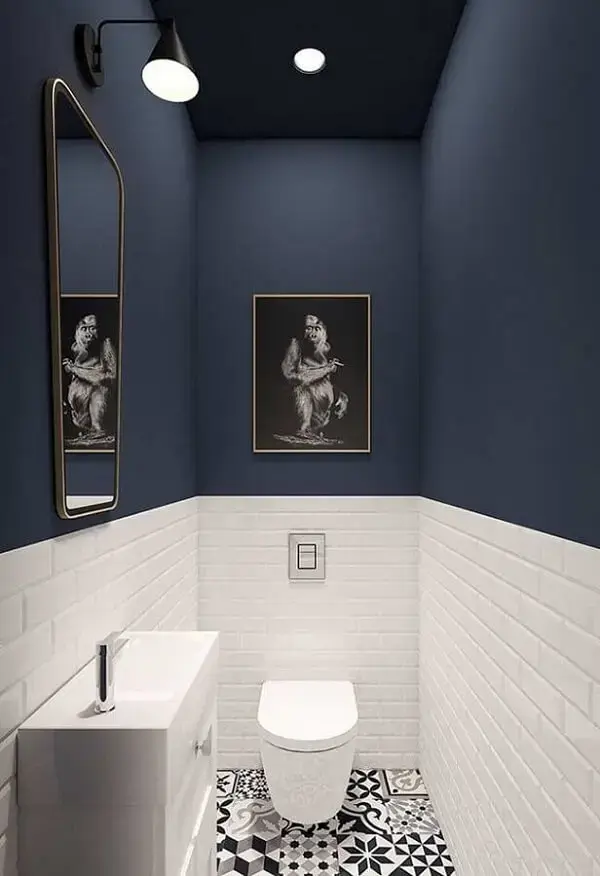 Banheiro decorado com cerâmica branca e parede pintada de azul marinho. Fonte: Jeito de Casa