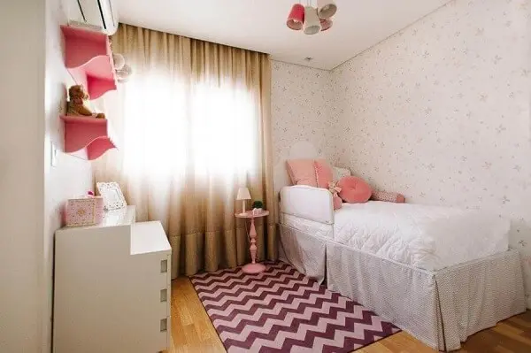 Delicada decoração de quarto de menina simples com tapete rosa chevron. Fonte: Codecorar
