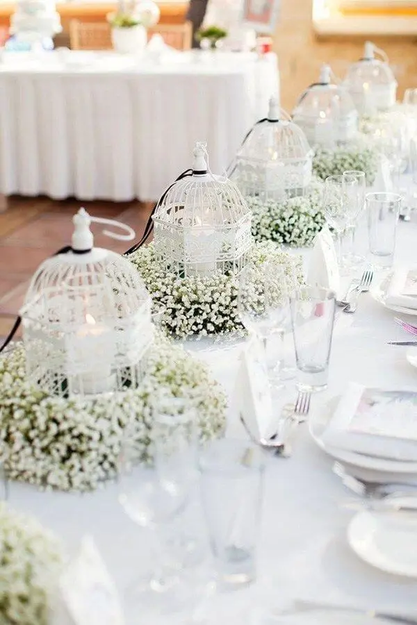 Gaiolas decorativas com flor mosquitinho e velas para a decoração de casamento