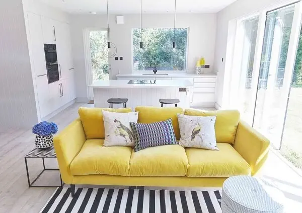 Sala com sofá amarelo e decoração clean