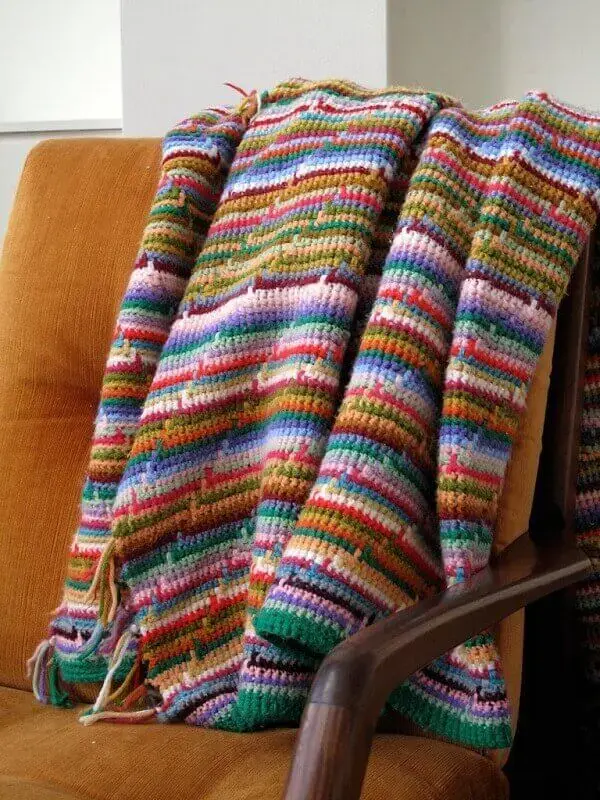 Manta colorida para sofá feita em crochê tunisiano