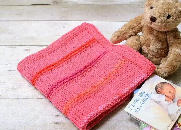 Manta de bebê em tom rosa feito em diferentes tipos de pontos de crochê tunisiano