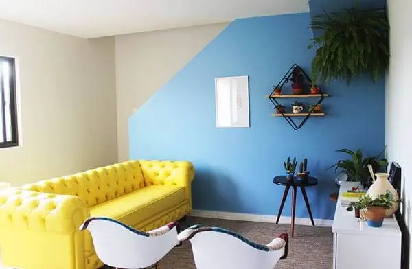 Sala pequena com sofá amarelo chesterfield