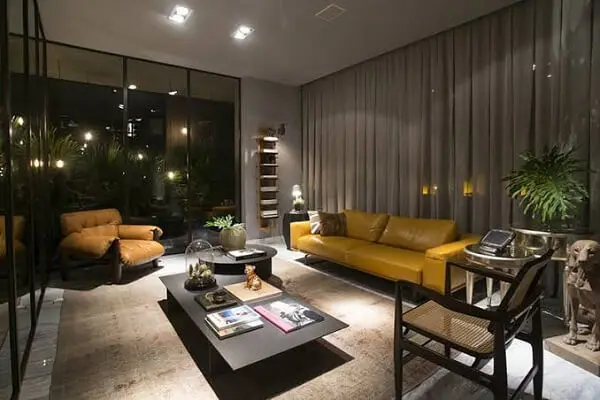 Sala de estar com poltrona mole e sofá amarelo de couro