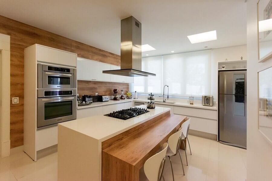 cozinha planejada com cooktop e ilha com bancada de madeira Foto Jannini Sagarra Arquitetura
