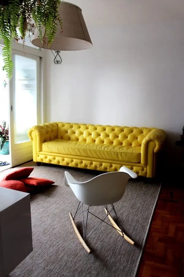 decoração simples para sala com sofá amarelo e cadeira eames de balanço Foto Pinterest