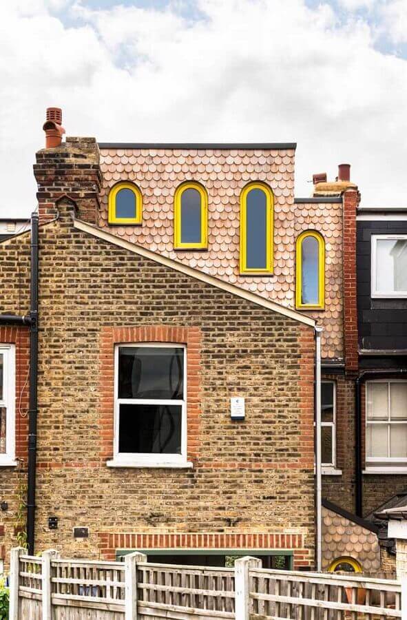 fachada de tijolinho a vista decorada com janelas amarelas Foto HomeNotes