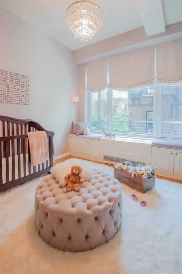 puff redondo capitonê para quarto de bebê com berço de madeira e tapete branco felpudo Foto Ideaz Home