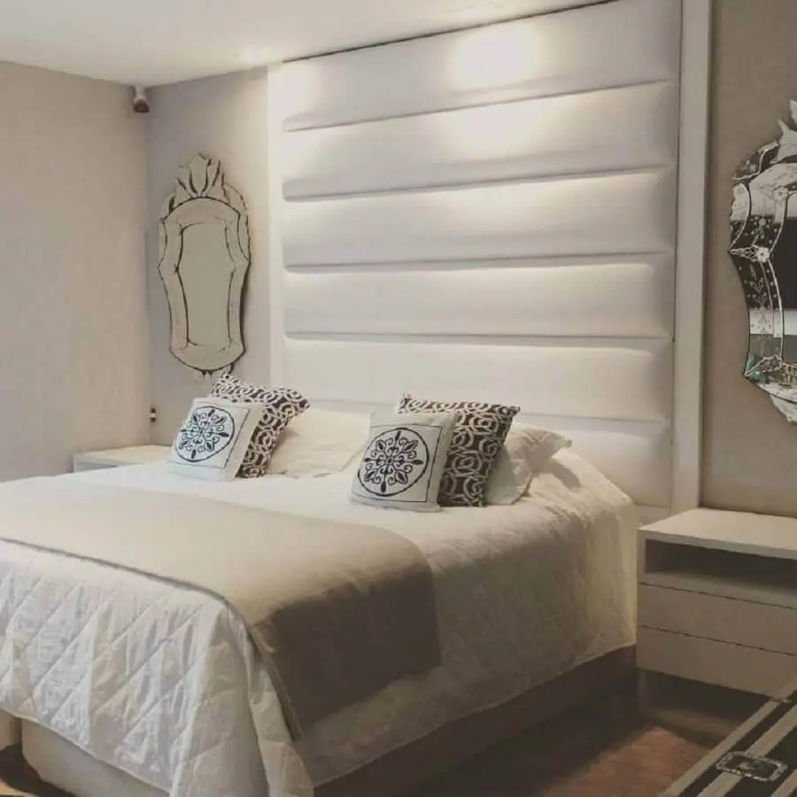 quarto branco decorado com cabeceira estofada e espelho provençal Foto ArqVita