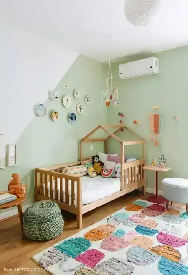 quarto infantil decorado com parede verde claro e tapete colorido Foto Histórias de Casa