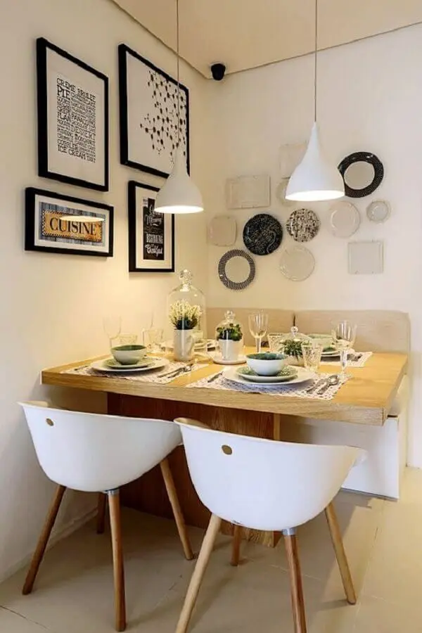 sala de jantar pequena decorada com cadeira branca e vários quadros na parede Foto Simples Decoração