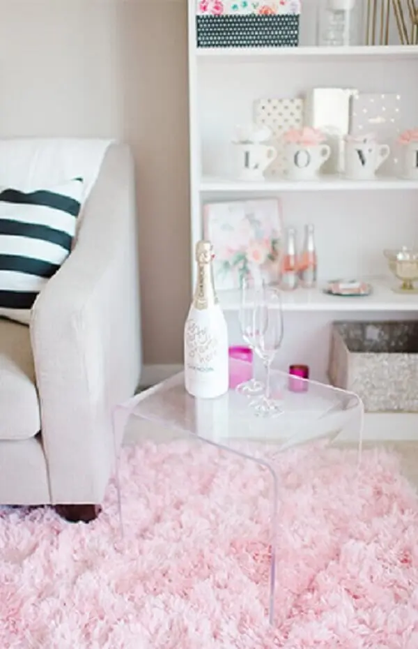 Sala com tapete rosa felpudo e mesa de acrílico