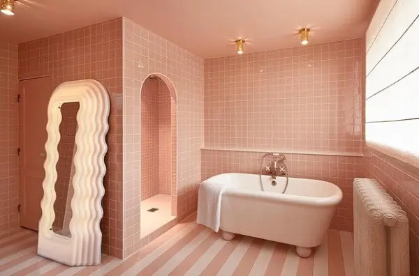 Banheiro rosa claro e branco com padrões de piso diferentes 