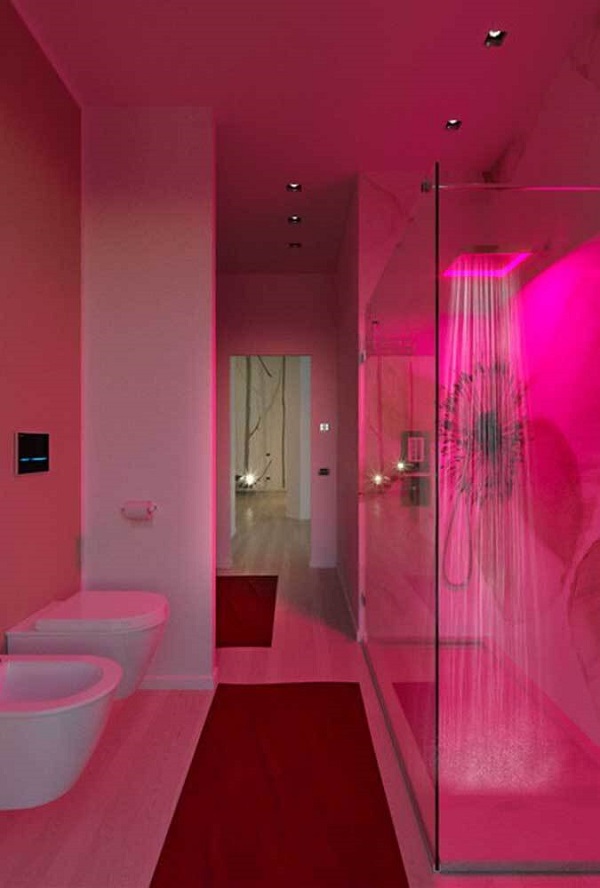 Banheiro rosa com chuveiro iluminado 
