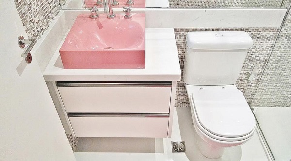 Banheiro rosa com cuba de apoio rosa e pastilhas de vidro 