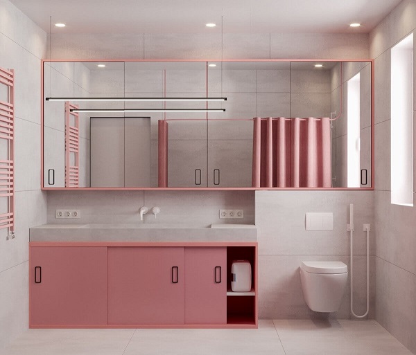 Banheiro rosa com gabinete rosa e espelho grande