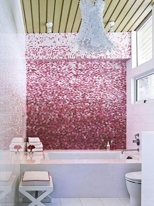 Banheiro rosa com revestimentos rosa e banheira branca 