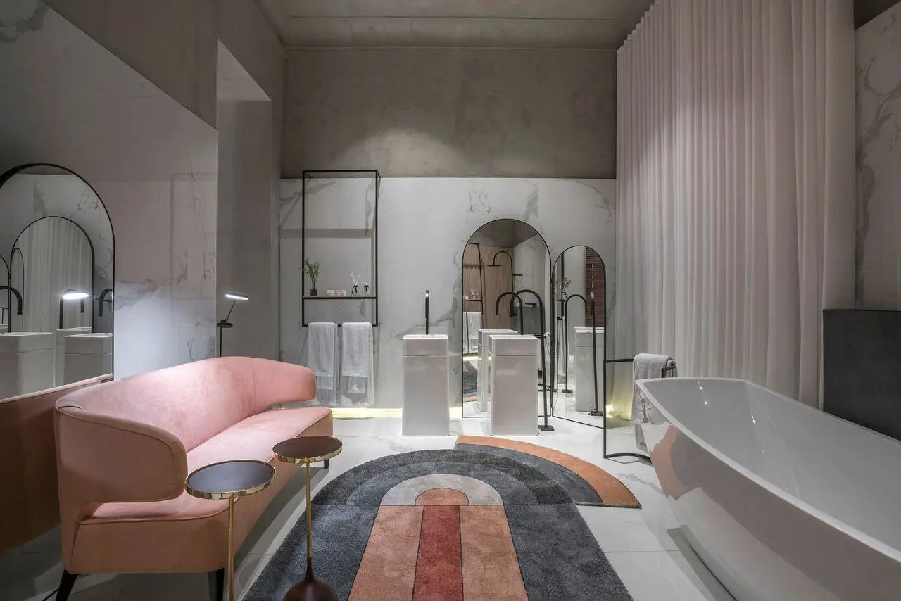Banheiro rosa e cinza com sofá rosa 
