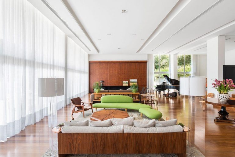 Decoração de sala ampla com chaise verde como ponto focal