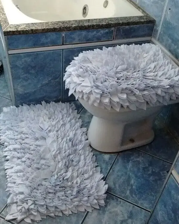 O tapete de retalhos branco deixa o banheiro com uma decoração clean