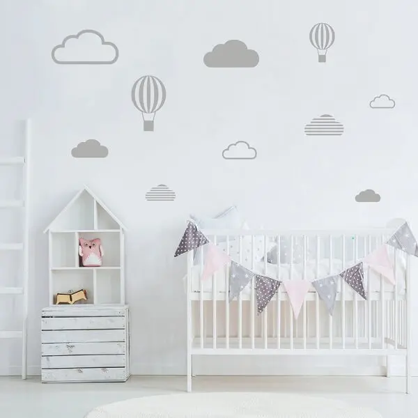 Quarto de bebê cinza com nuvens e balões e móveis brancos