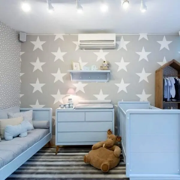 Quarto de bebê cinza e azul com papel de parede de estrela e móveis azul claro 