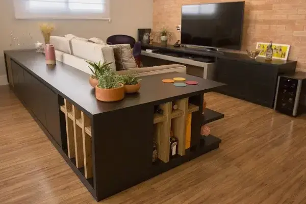 O aparador segue o formato do sofá da sala de tv moderna