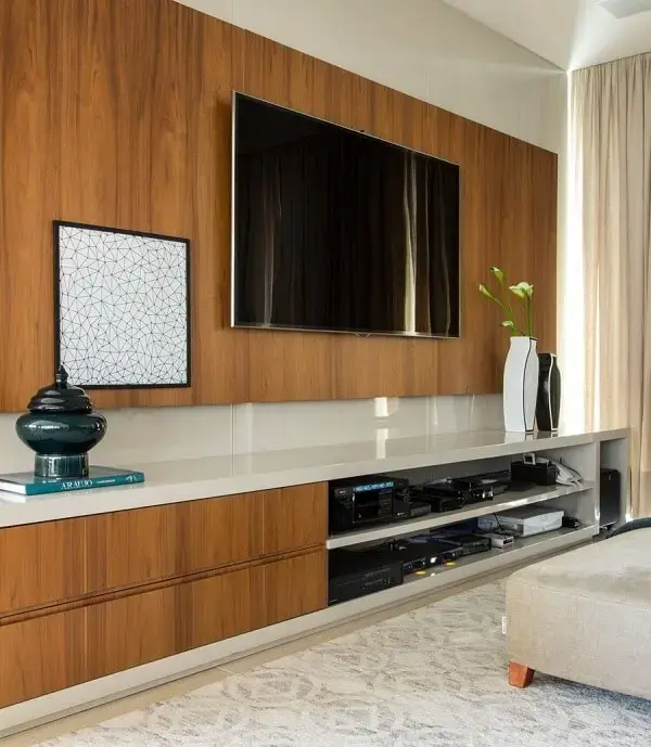 Sala de tv com tapete estampado clara e gavetas amadeiradas