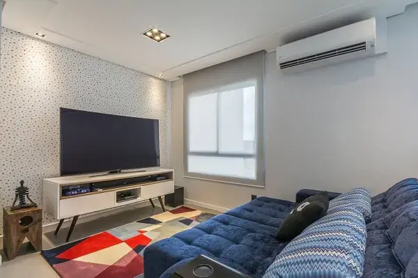 Sala de tv moderna e aconchegante com papel de parede de bolinha e sofá retrátil e reclinável