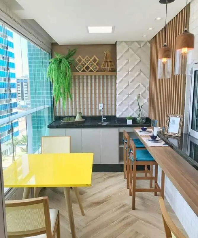 apartamento com área gourmet pequena e simples decorada com mesa amarela e cadeira azul Foto Dicas de Mulher