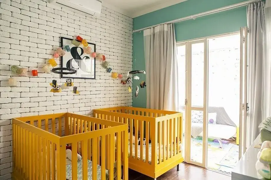 berço para quarto de bebê amarelo decorado com parede de tijolinho branco Foto Bebe Mamãe