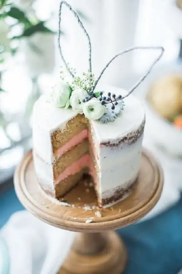 bolo de páscoa rústico decorado com orelha de coelho e flores no topo Foto Woman's Day
