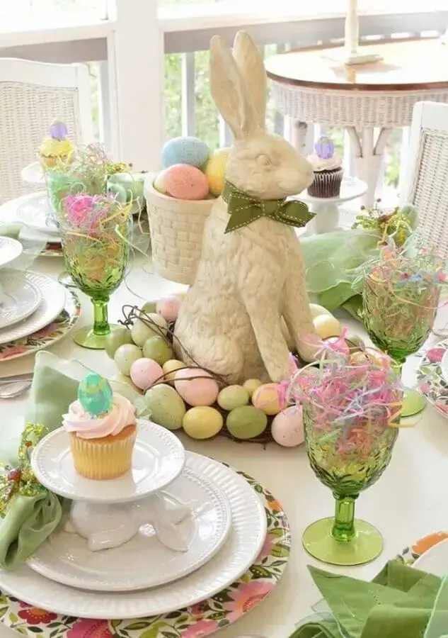 coelho decorativo para mesa posta de páscoa com vários ovinhos coloridos