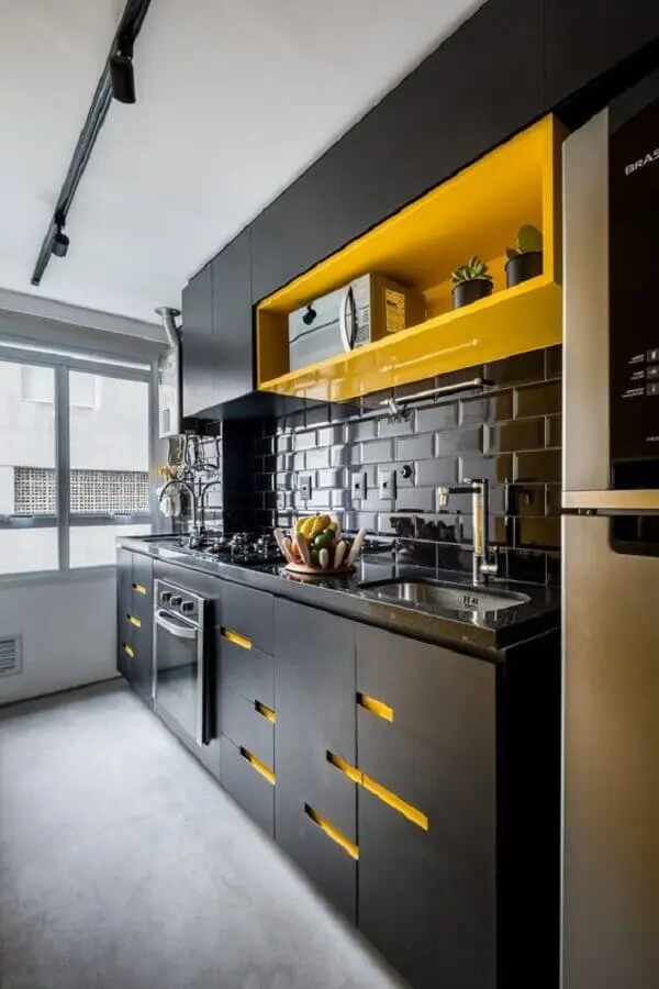 Cozinha preta com eletrodomésticos em aço inoxidável
