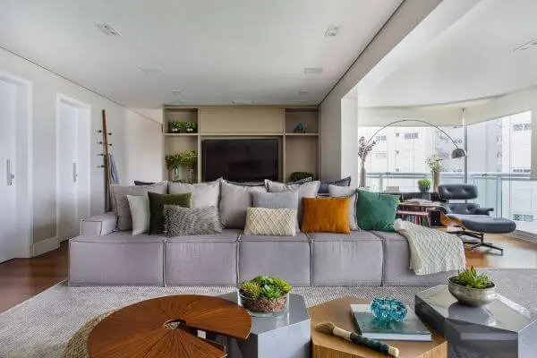 Sala de estar com sofá cinza e almofadas coloridas