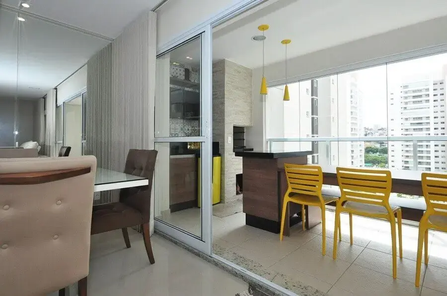 decoração com cadeiras amarelas para área gourmet pequena com churrasqueira Foto Condecorar Arquitetura e Interiores
