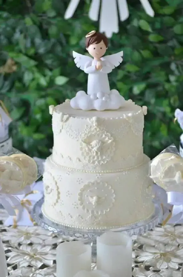 decoração de mesa de batizado com bolo branco com anjinho no topo Foto Bela Pequena