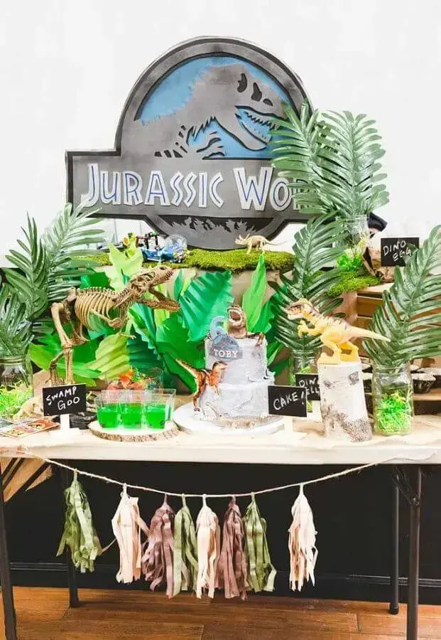 decoração festa dinossauro com bonecos e folhas grandes Foto Pinterest