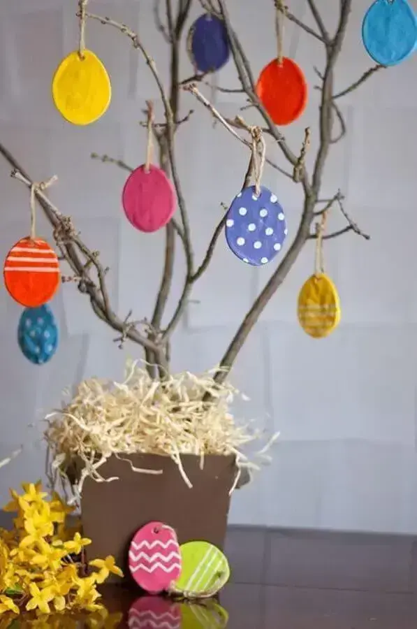 rustic Easter ornament with colorful little eggs hanging from dried branches Photo Dekorella