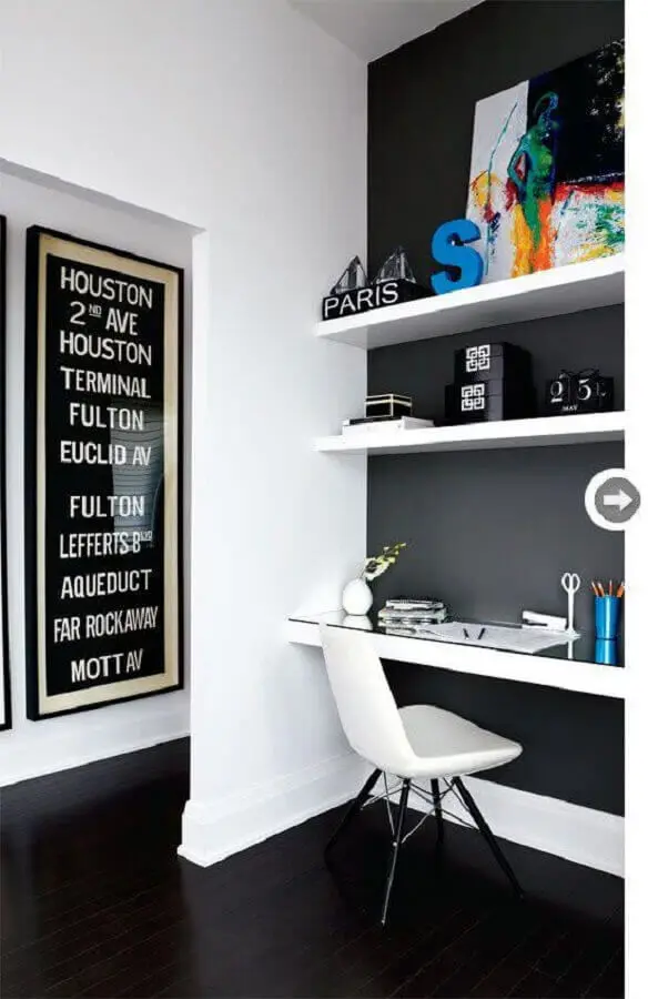 home office decorado com parede preta e prateleiras e bancada branca Foto Achados de Decoração