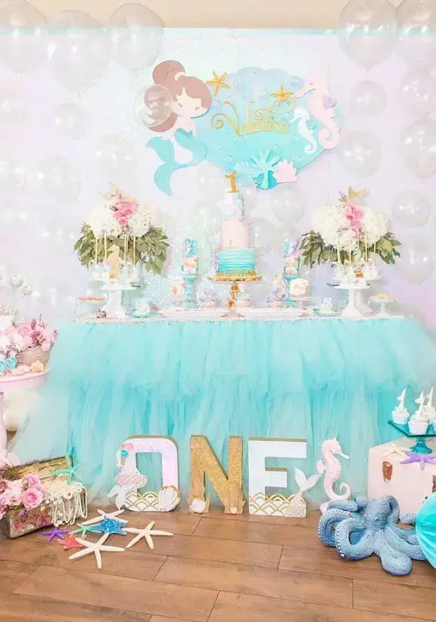 mesa de festa infantil sereia decorada com babado azul e balões transparentes Foto Pinterest