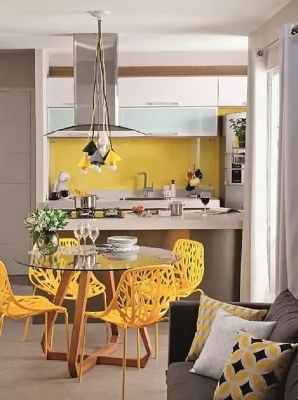 Cadeiras para cozinha amarelas e pendentes metálicos coloridos trazem vida para o ambiente