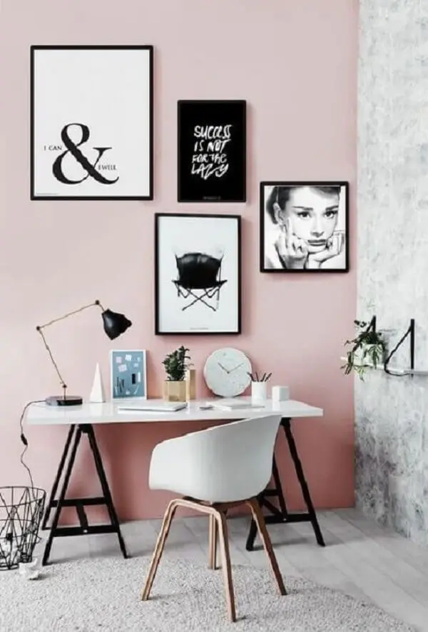 Escritório com parede rosa e quadros decorativos de moda
