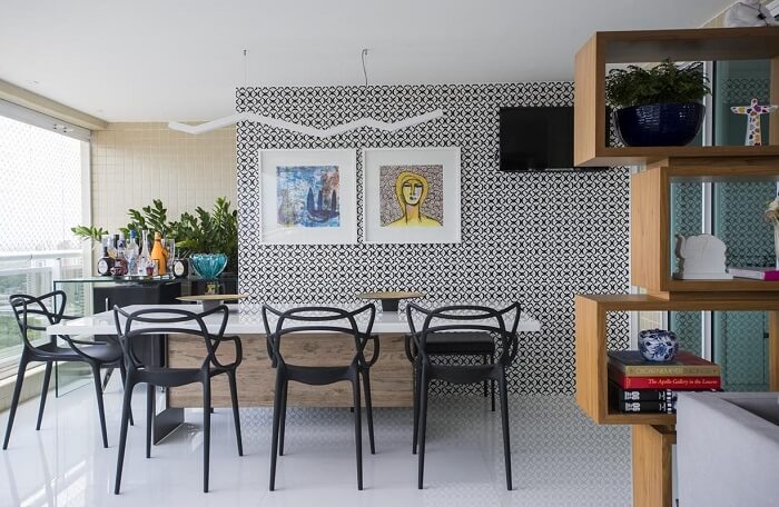Mesa de jantar com cadeira preta e parede estampada