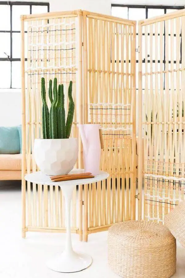 O biombo de madeira complementa a decoração da sala de estar com leveza