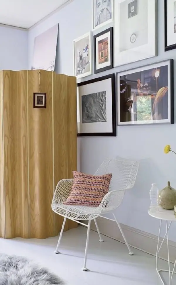 O biombo de madeira traz privacidade em um dos cantos do cômodo