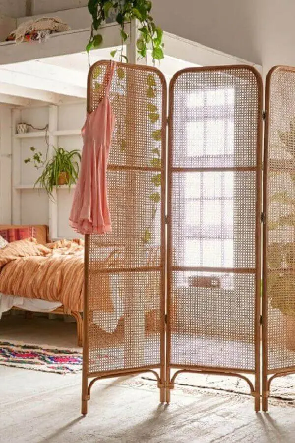 O biombo de madeira treliça decora com elegância o quarto de casal