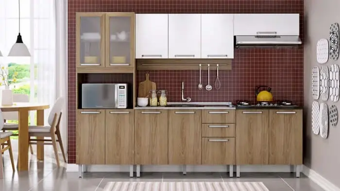 Os armários superiores em tom branco quebram a monotonia da madeira na cozinha modulada. Fonte: Itatiaia