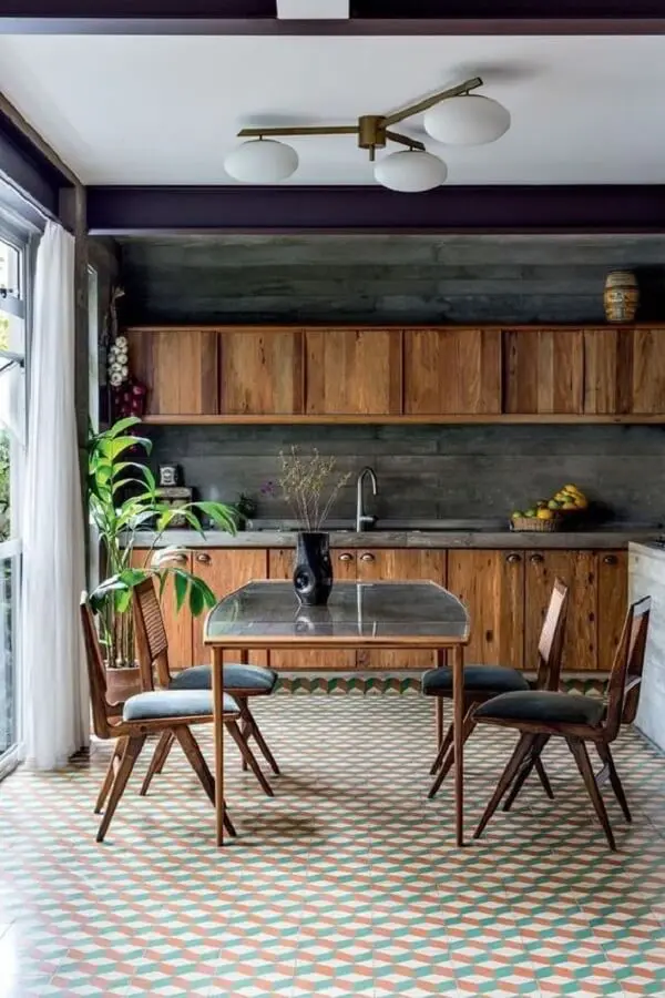 Piso geométrico e cadeiras para cozinha com assento estofado cinza chamam a atenção no cômodo