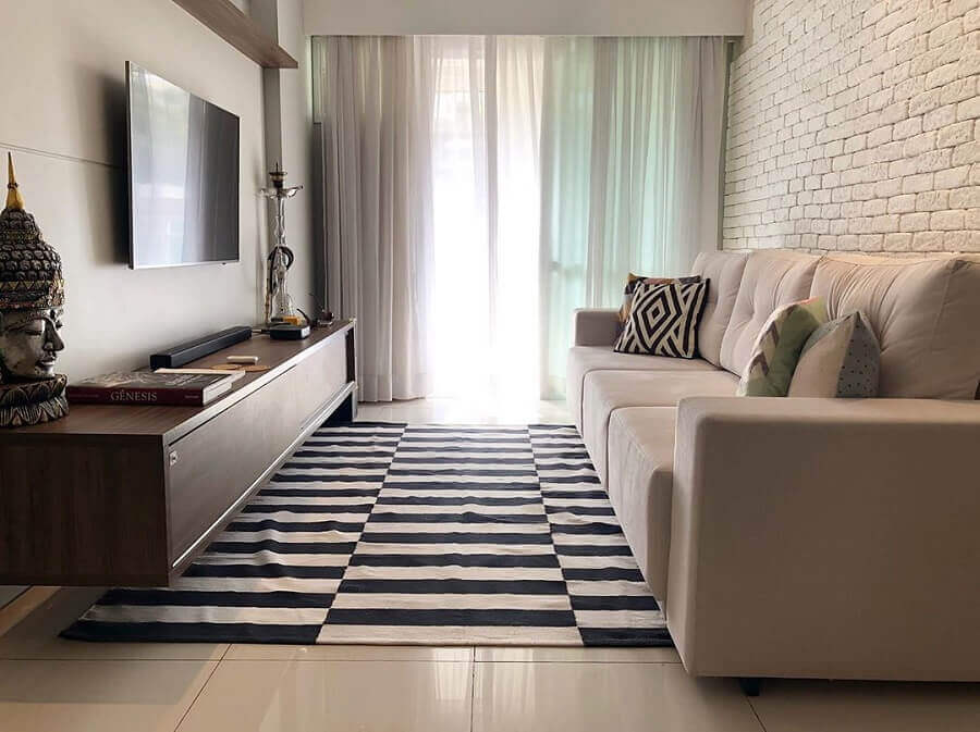 Sala pequena decorada com tapete listrado e sofá bege Foto Rafaella Nogueira Arquitetura